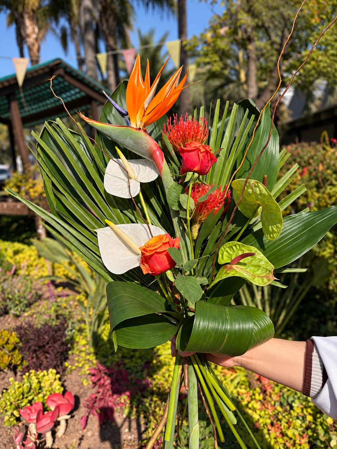 Colourful bouquet with bird-of-paradise flowers, roses and tropical foliage